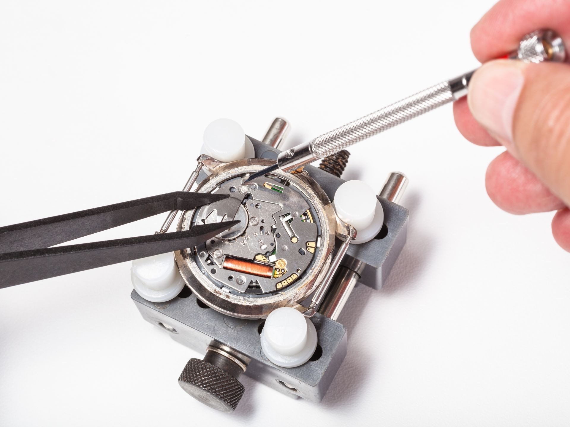 watchmaker workshop - replacement battery in quartz watch close up on white background